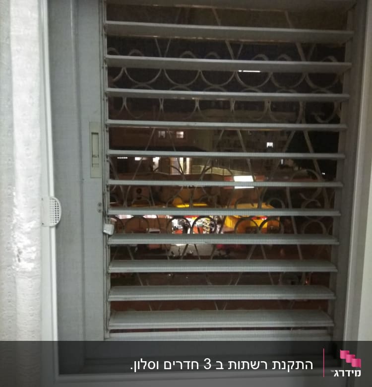 תריסי אלומיניום אפורים עם נוף לילי ברקע